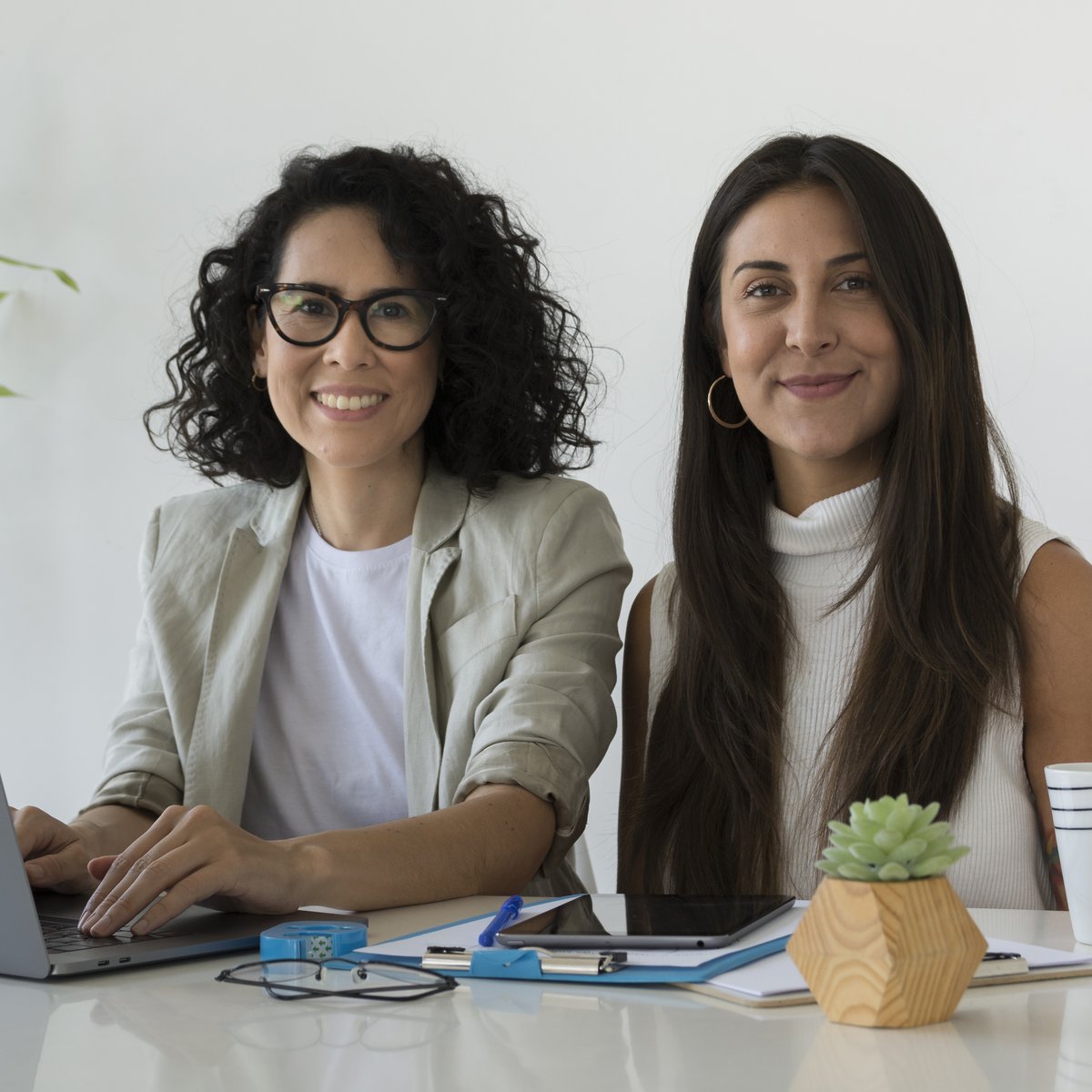 Two operators working together with AI tools, humans + tech compounding